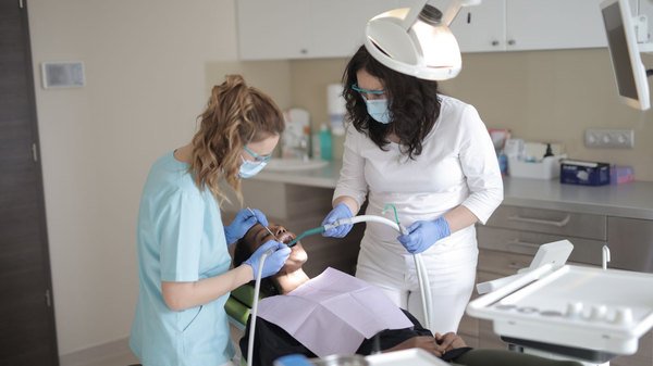 Equipe odontológica realizando procedimento estético em consultório